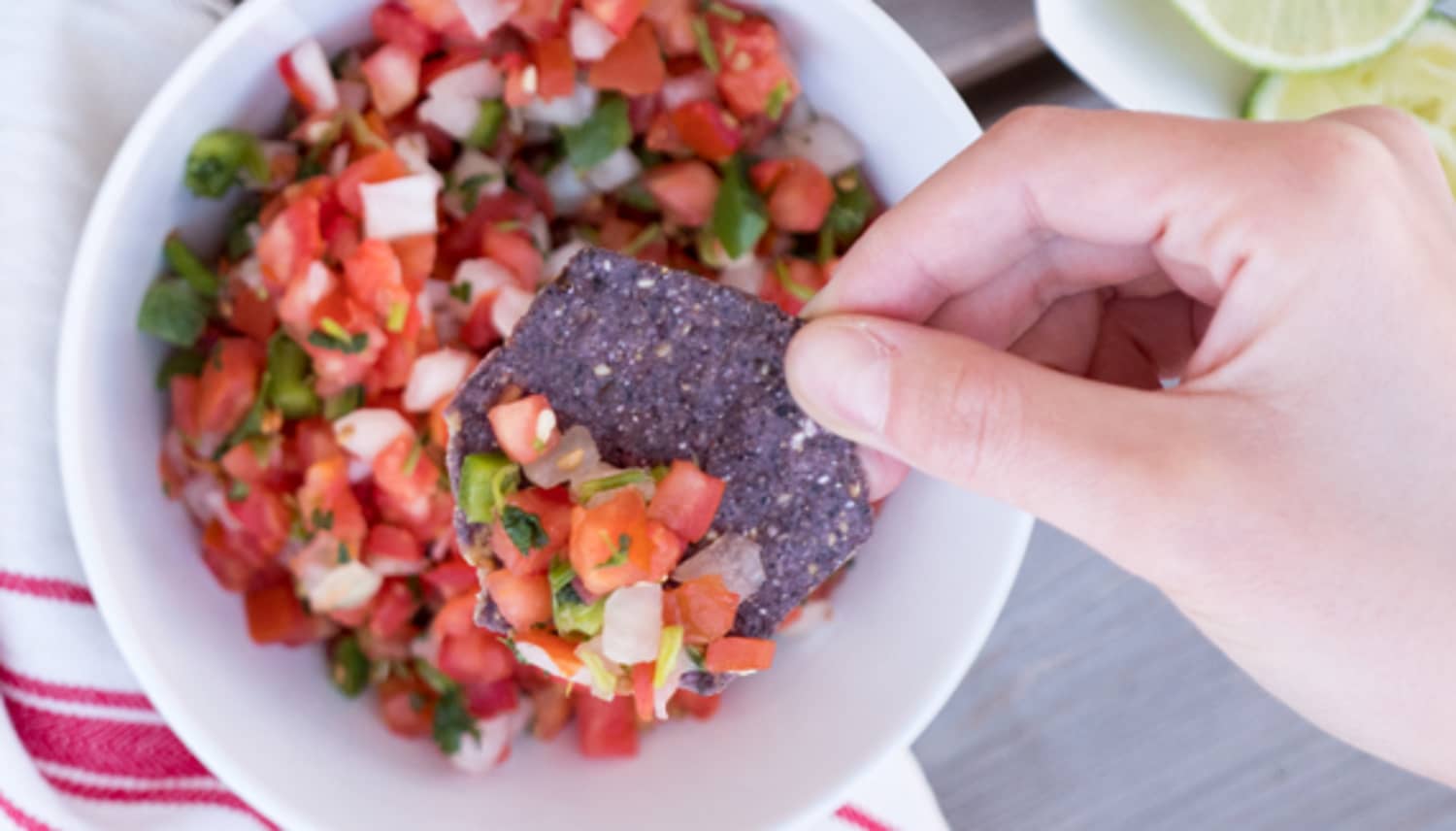 Hand using a Food Should Taste Good chip to scoop up salsa 